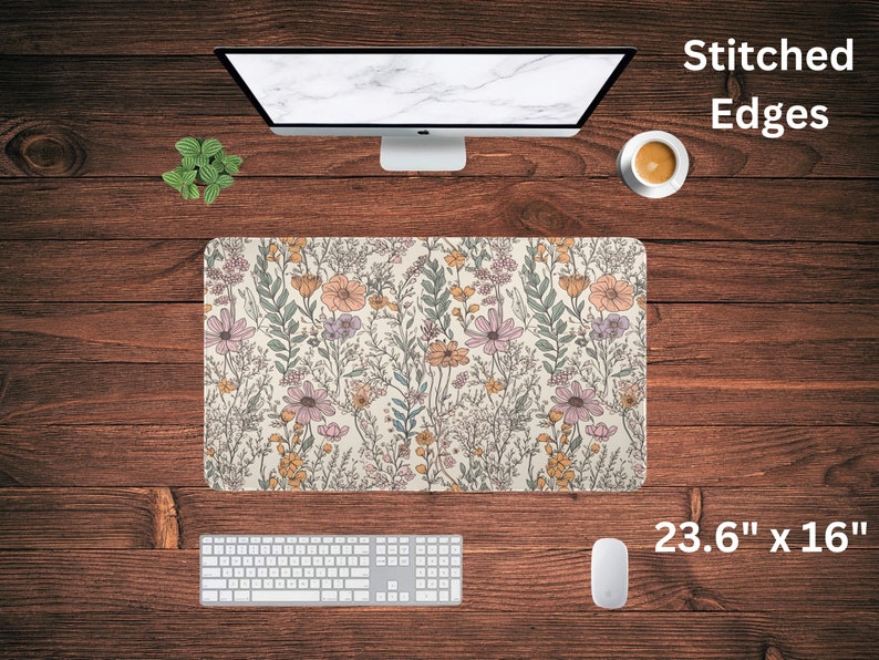 May include: A floral patterned mouse pad with stitched edges. The mouse pad is 23.6 inches by 16 inches and features a light beige background with a variety of pink, yellow, and green flowers.