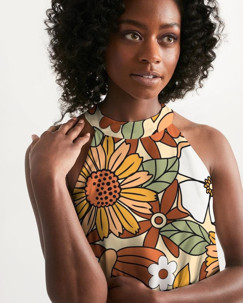 May include: A halter top with a retro floral print in shades of orange, brown, green, and white. The print features large flowers and leaves.