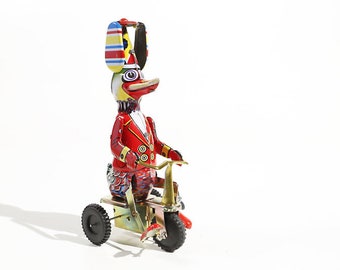 Giocattolo da collezione in latta raffigurante un'anatra su un triciclo.