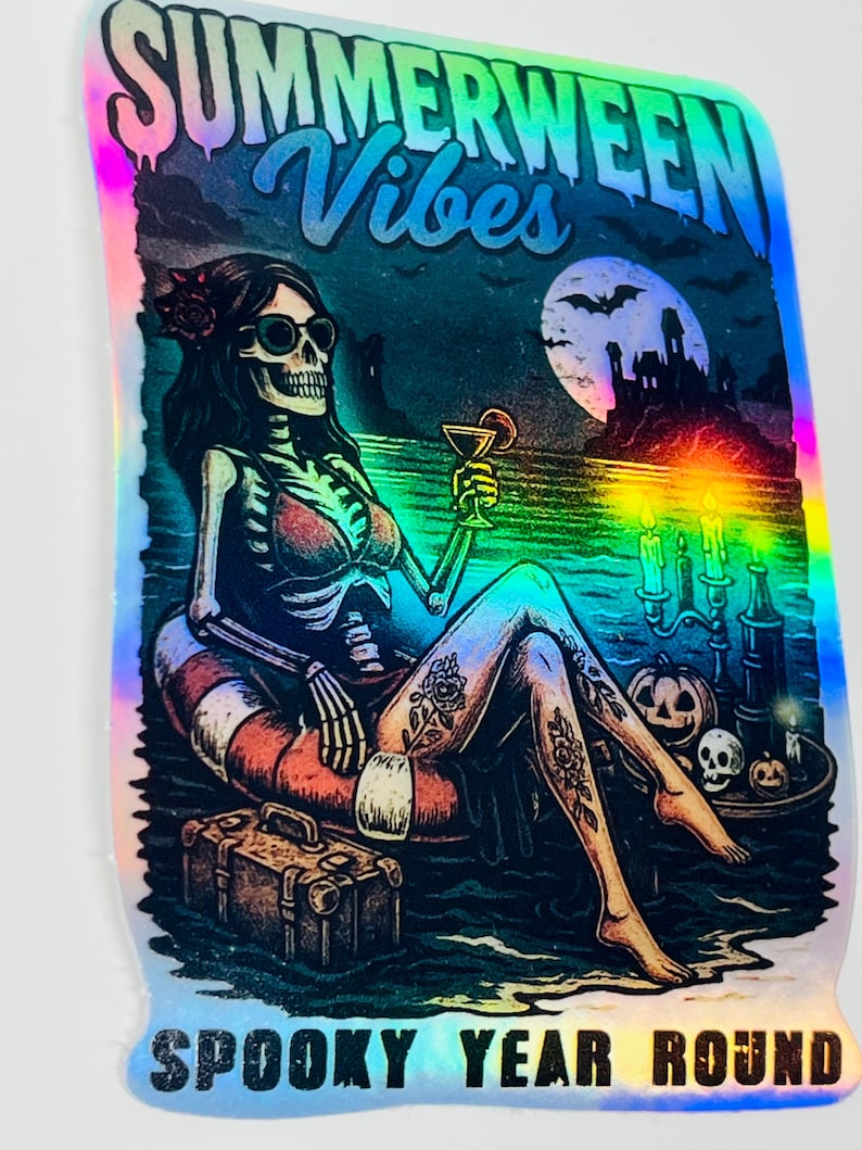 Puede incluir: Pegatina hologr&aacute;fica con un esqueleto descansando en un flotador, sosteniendo un c&oacute;ctel. La pegatina presenta el texto "Summerween Vibes" y "Spooky Year Round". El esqueleto tiene tatuajes y lleva gafas de sol.