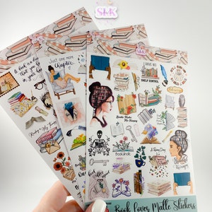 Puede incluir: Una mano sostiene varias hojas de "Book Lover Malle Stickers". Las pegatinas presentan ilustraciones de libros, lectura y elementos relacionados. Las pegatinas tienen texto como "Just one more chapter" y "Reading is my therapy."
