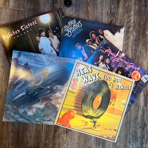 May include: A collection of eight vintage vinyl records, including albums by The Pointer Sisters, The Isley Brothers, and Heatwave. The records are in various colours and feature different album covers.