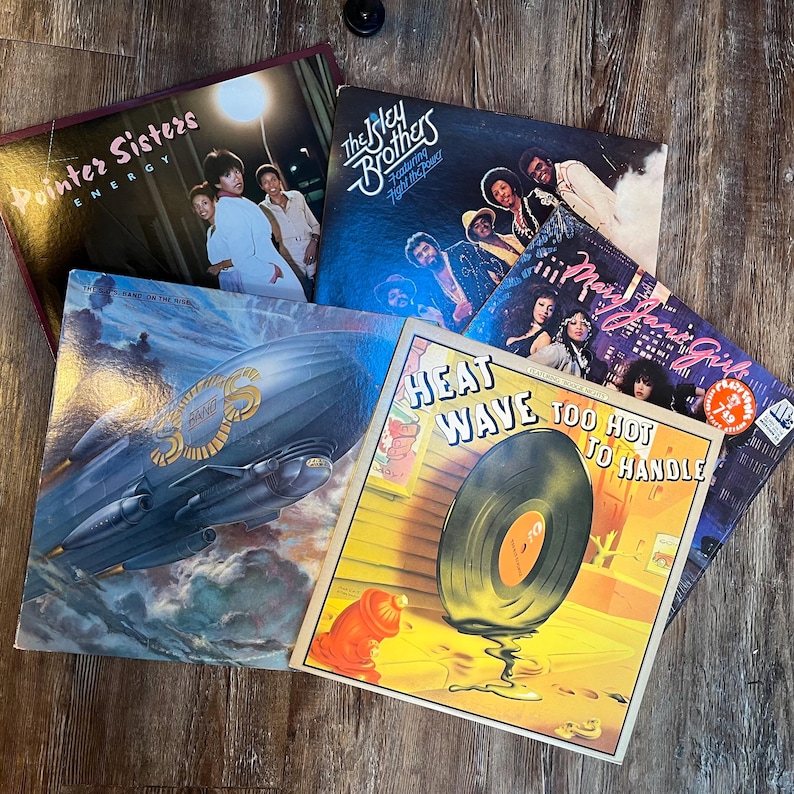 May include: A collection of eight vintage vinyl records, including albums by The Pointer Sisters, The Isley Brothers, and Heatwave. The records are in various colours and feature different album covers.