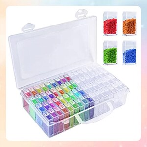 May include: A clear plastic storage box with a handle, containing 48 small clear containers filled with colourful beads. The box has a lid and is designed for organising and storing small items.