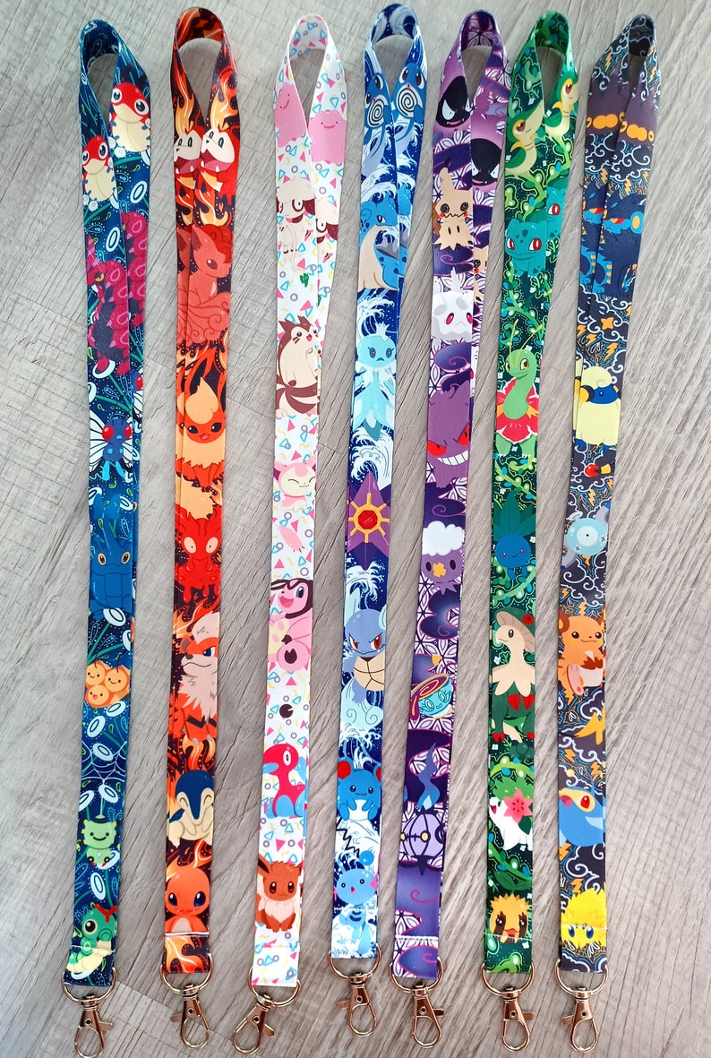 May include: Set of seven colorful lanyards featuring different Pokemon characters. Each lanyard has a unique design with a variety of colors and patterns. The lanyards are approximately 18 inches long and have a metal clip at the end.