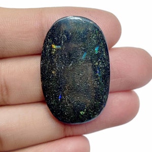 May include: A dark gray oval opal cabochon with iridescent flashes of blue, green, and red.
