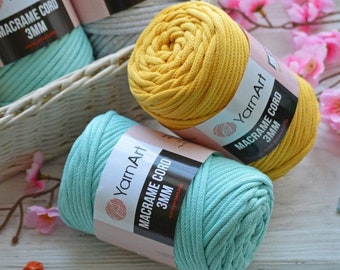 May include: Three spools of macrame cord in yellow, light blue, and gray. Each spool has a label that reads "YarnArt Macrame Cord 3MM".