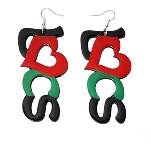 May include: A pair of black, red, and green statement earrings with the word "LOVE" in a heart shape and the word "BLACK" underneath.
