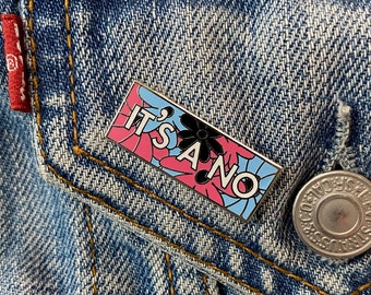 May include: A blue, pink, and white enamel pin with a black flower and the text "It's a no" on a denim jacket.