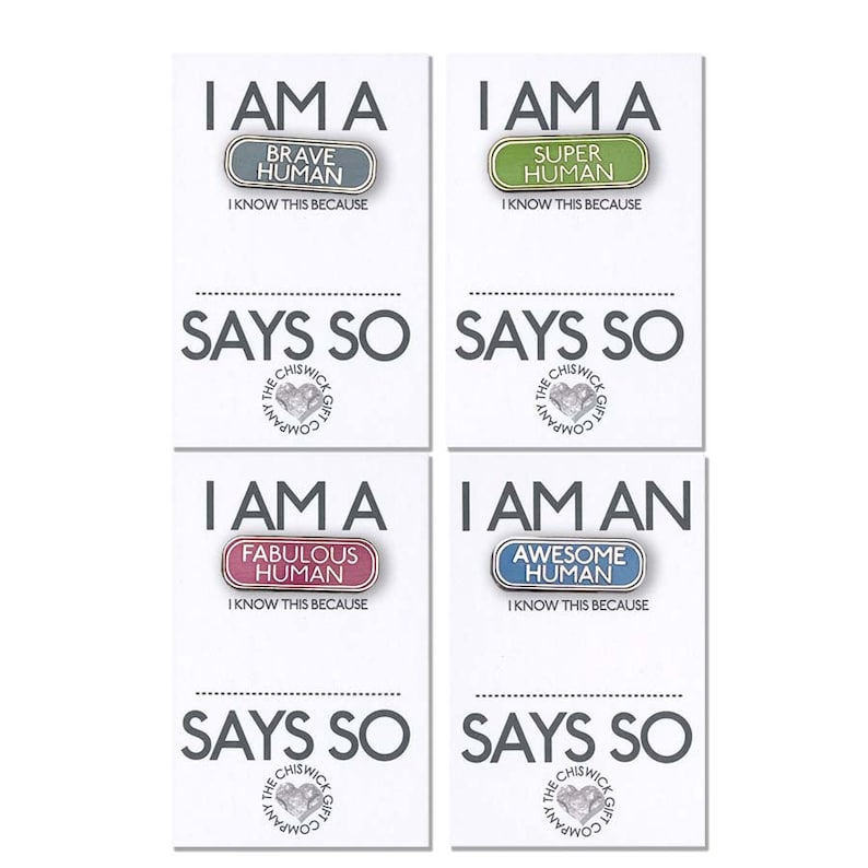 May include: Four white cards with colorful badges and the text "I am a [badge text] Human. I know this because says so." The badges are green, blue, pink, and gray. The text "The Chiswick Gift Company" is on the bottom of each card.