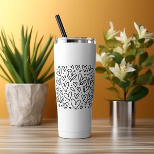 May include: White stainless steel tumbler with a black straw and a black and white heart pattern.