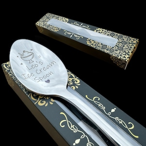 May include: A silver ice cream spoon with the text "Leo's Ice Cream Spoon" engraved on the bowl. The spoon is in a black box with a gold design.
