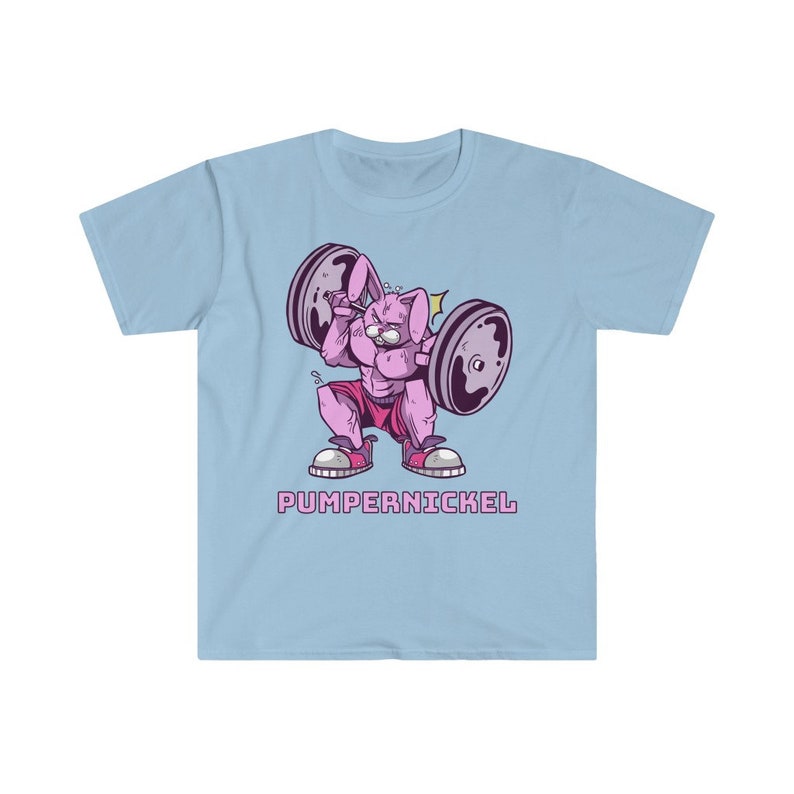 May include: Light blue t-shirt featuring a cartoon rabbit lifting weights. The rabbit is pink and muscular, wearing pink shorts and sneakers. The barbell has gray weights. The text "PUMPERNICKEL" is below the rabbit in pink letters.