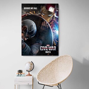 May include: A movie poster for Captain America: Civil War, featuring Captain America and Iron Man in a fight. The poster has the text "DIVIDED WE FALL" at the top and "MARVEL'S CAPTAIN AMERICA: CIVIL WAR" and "MAY 6" at the bottom.
