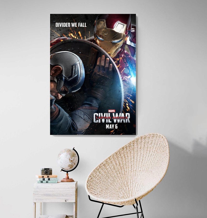 May include: A movie poster for Captain America: Civil War, featuring Captain America and Iron Man in a fight. The poster has the text "DIVIDED WE FALL" at the top and "MARVEL'S CAPTAIN AMERICA: CIVIL WAR" and "MAY 6" at the bottom.