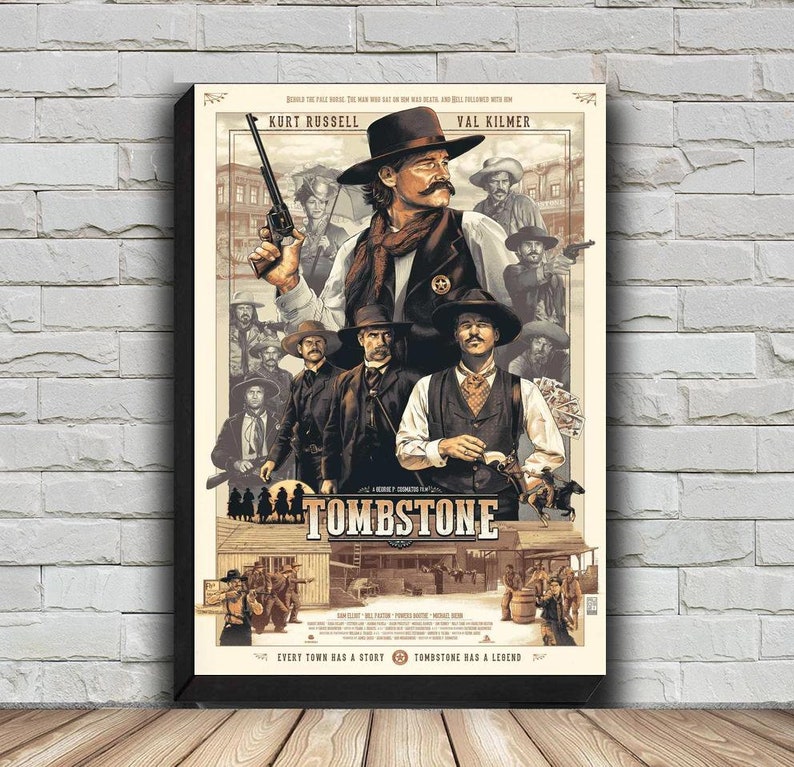 May include: A vintage-style movie poster for the film "Tombstone" featuring Kurt Russell and Val Kilmer. The poster is in shades of brown, beige, and white with a black frame. The text on the poster reads "Tombstone" and "Every town has a story. Tombstone had a legend."
