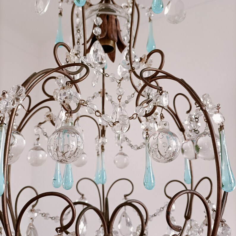 May include: A vintage chandelier with a wrought iron frame and crystal and blue glass drops.
