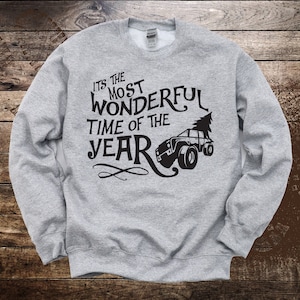 May include: Gray sweatshirt with a black graphic that says "It's the most wonderful time of the year" with a cartoon truck carrying a Christmas tree.