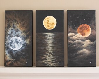 May include: Set of three vertical canvas paintings depicting the moon in different phases. One shows a full moon in a cloudy sky, another a moon over water, and the last a red moon with stars.