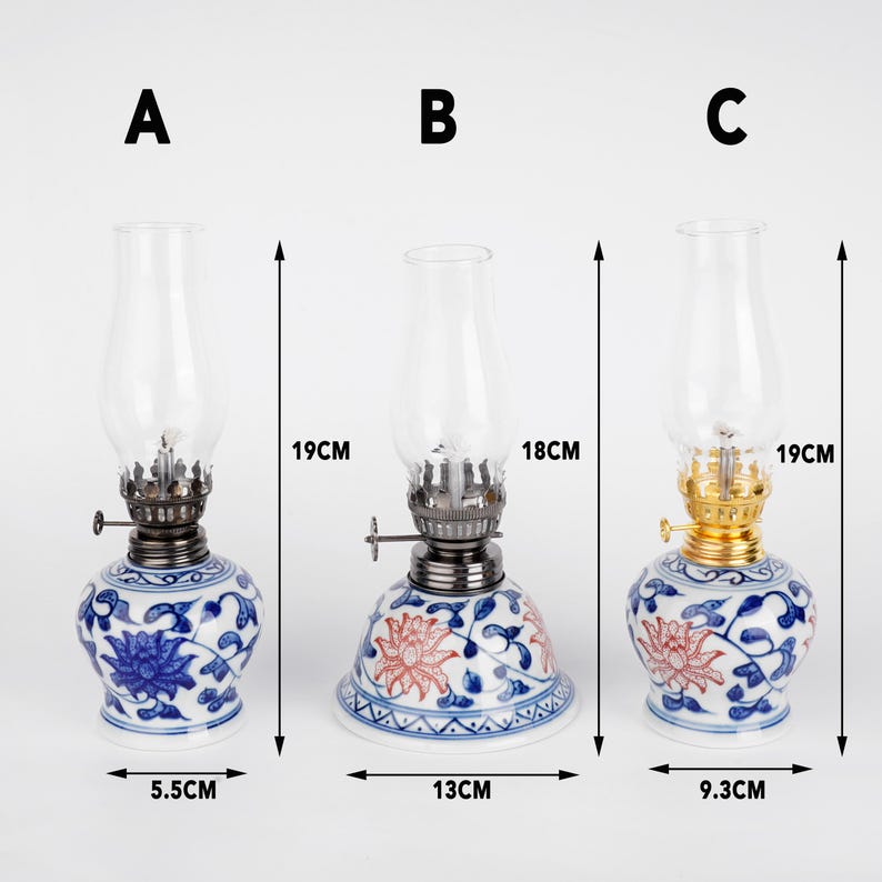 Puede incluir: Tres l&aacute;mparas de aceite de cer&aacute;mica con dise&ntilde;os florales azules y blancos. Las l&aacute;mparas miden 19 cm de alto y tienen una base de 5,5 cm de di&aacute;metro. Las l&aacute;mparas est&aacute;n etiquetadas como A, B y C.