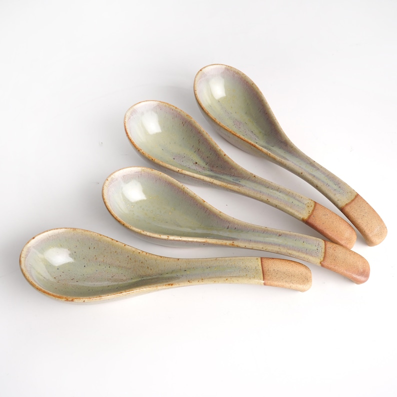 May include: Set of four ceramic soup spoons with a speckled green glaze and brown handles.