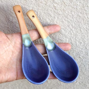 Puede incluir: Dos cucharas de sopa de cerámica con un cuenco de color morado intenso que se transforma en un esmalte verde claro en el cuello, terminando en un mango liso de color tostado con un pequeño orificio circular en la parte superior.