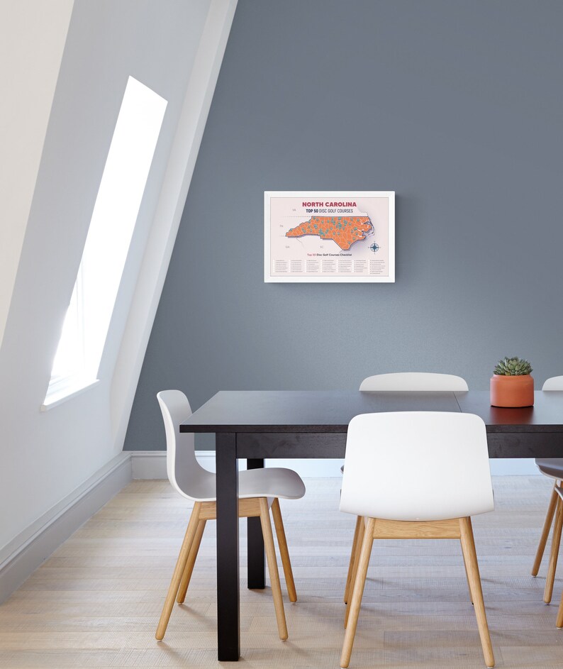 May include: A framed map of North Carolina highlighting the top 50 golf courses in the state. The map is printed on white paper with a light orange outline of the state and red dots marking the golf courses. The title "North Carolina Top 50 Golf Courses" is printed in red at the top of the map.