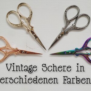Könnte beinhalten: Vier Vintage-Scheren in verschiedenen Farben: Gold, Silber, Roségold und Regenbogen. Die Scheren haben verzierte Griffe und sind in einem Kreis auf weißem Hintergrund angeordnet.