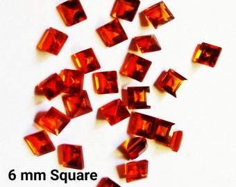 May include: A collection of square-cut, orange-red gemstones, each approximately 0.24 inches (6 mm) in size, scattered on a white surface. The image includes the text "6 mm Square". These faceted gems have a brilliant, reflective quality.