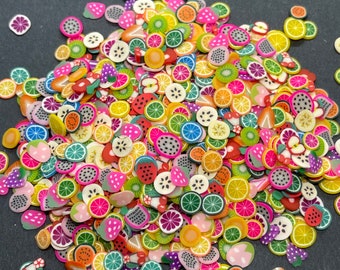 May include: A large assortment of colorful fruit-shaped polymer clay charms. The charms are in various shapes, including lemons, limes, strawberries, pineapples, and watermelons. The charms are perfect for adding a touch of whimsy to jewelry, crafts, and other projects.