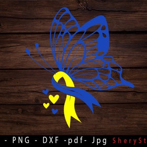 May include: A blue butterfly with yellow ribbon and small hearts. The butterfly is on a brown wooden background.