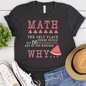 Könnte beinhalten: Dunkelgraues T-Shirt mit dem Text "MATH" in rosa Buchstaben. Der Text "THE ONLY PLACE WHERE PEOPLE BUY 66 WATERMELONS AND NO ONE WONDERS WHY..." ist unter dem Wort "MATH" gedruckt.