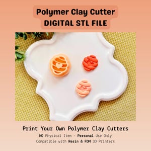 May include: Three polymer clay creations in orange and red hues, each with a heart design, rest on a white, decorative plate. The text "Polymer Clay Cutter DIGITAL STL FILE" is at the top. The bottom text reads "Print Your Own Polymer Clay Cutters".