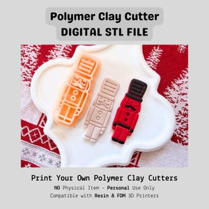 May include: Three polymer clay cutter designs shaped as nutcrackers, in orange, beige, and red with black details, presented on a white, scalloped plate. The image includes text that reads "Polymer Clay Cutter DIGITAL STL FILE" and "Print Your Own Polymer Clay Cutters."