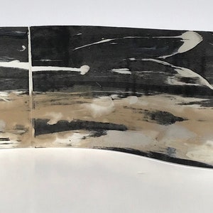May include: Abstract art piece made of three panels with a wavy, organic shape. The panels are painted in shades of black, white, and beige with brushstrokes and splatters of paint.