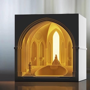 May include: A white papercraft model of a wedding ceremony taking place in a cathedral. The bride and groom are standing on a platform with a large window behind them. The cathedral has a vaulted ceiling and stained glass windows.