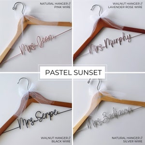 Pu&ograve; includere: Quattro grucce in legno con fiocchi di tulle e lettere in filo metallico personalizzate. Le grucce sono in due diverse tonalit&agrave; di legno: naturale e noce. Le lettere in filo metallico sono in quattro colori diversi: oro rosa, argento, nero e lavanda. Le grucce sono etichettate con il testo "Sig.ra Jeon", "Sig.ra Murphy", "Sig.ra Serpe" e "Sig.ra Badeaux".