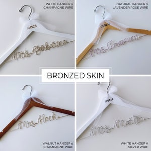 Pu&ograve; includere: Quattro diverse grucce di legno con tulle bianco e un'iscrizione in filo metallico che dice "Sig.ra" seguita da un cognome. Le grucce sono etichettate con il tipo di legno e filo utilizzato. Le date 10-15-23, 05-06-23, 10-07-22 sono stampate sulle grucce.