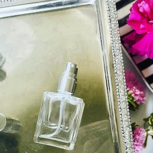glass perfume bottle with silver atomizer andtop. Holds 15 ml of perfume