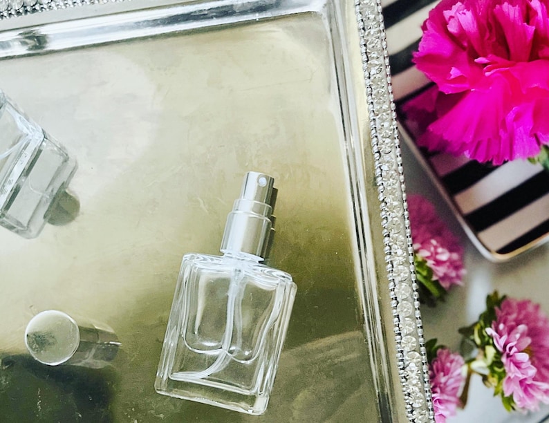 glass perfume bottle with silver atomizer andtop. Holds 15 ml of perfume