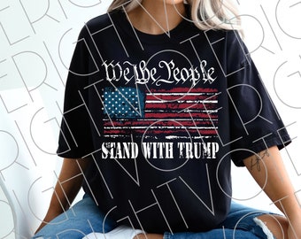 Könnte beinhalten: Schwarzes T-Shirt mit einem verblassten Design der amerikanischen Flagge und dem Text "We the People" und "Stand With Trump". Die Flagge hat rote, weiße und blaue Farben.