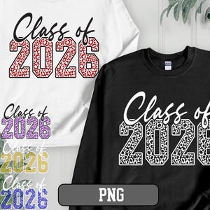 以下が含まれることがあります： 「Class of 2026」の文字が入った白と黒のスウェットシャツ。数字はヒョウ柄のデザインで埋められています。同じデザインのスウェットシャツが紫、金、青で表示されています。画像には「PNG」グラフィックも含まれています。