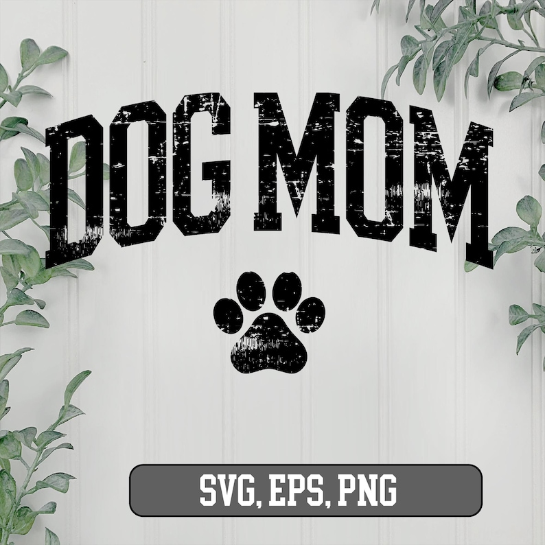 May include: Black and white graphic design with the text "DOG MOM" in a distressed font. A paw print is below the text. The design is on a white background.