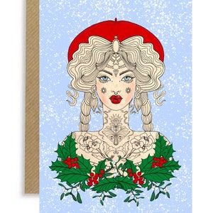 Könnte beinhalten: Eine Frau mit blonden Haaren und einem roten Barett trägt ein weißes Hemd mit einem floralen Tattoo. Sie ist von einem Kranz aus Stechpalme und Mistelzweig umgeben, auf einem blauen Hintergrund mit einem weißen Schneeeffekt.