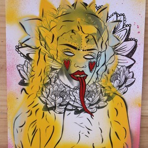 May include: A yellow and green illustration of a woman with a long red tongue, wearing a crown of flowers and a necklace of white flowers. The woman has red hearts on her cheeks and closed eyes. The background is a light pink and yellow.