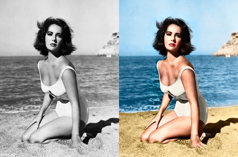 May include: A woman in a white swimsuit kneels on a sandy beach, with the ocean and a clear blue sky in the background. The image is a vintage photograph, with the woman's dark hair styled in a short bob. The swimsuit has a scoop neckline.
