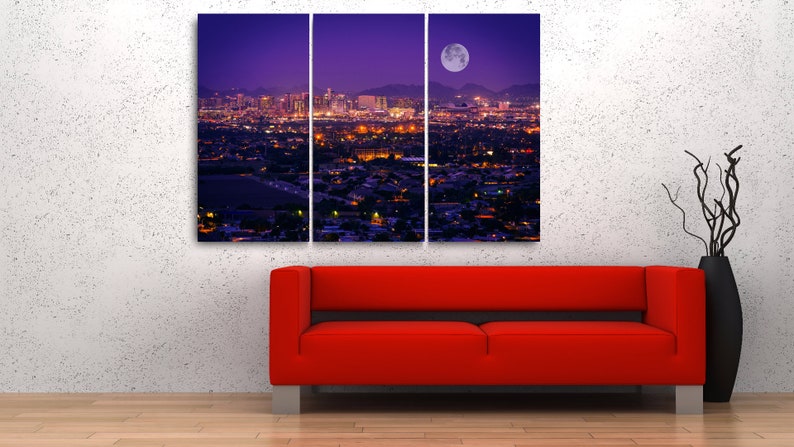 May include: A panoramic view of a city skyline at night with a large, bright moon in the sky. The city lights are visible in the distance, and the buildings are silhouetted against the purple sky.