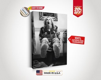 May include: Black and white photograph of a man sitting on a toilet with his mouth open in a scream. The man is wearing a patterned shirt and jeans. The photo is printed on a canvas.