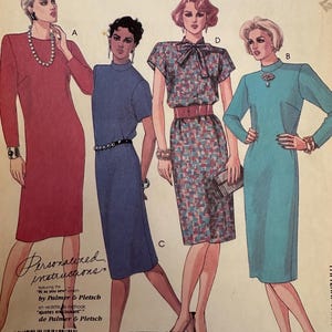 May include: Vintage McCall's sewing pattern featuring four dress designs. The pattern includes a red long-sleeve dress, a blue mock-neck dress, a patterned dress with a bow, and a teal dress. The pattern is marked "Petite-Able".