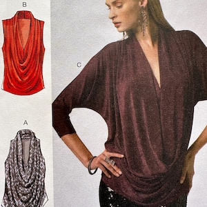 May include: A sewing pattern illustration featuring a deep burgundy cowl-neck top with three-quarter length sleeves, alongside two technical line drawings labeled A and B showing sleeveless variations of the same draped neckline design.